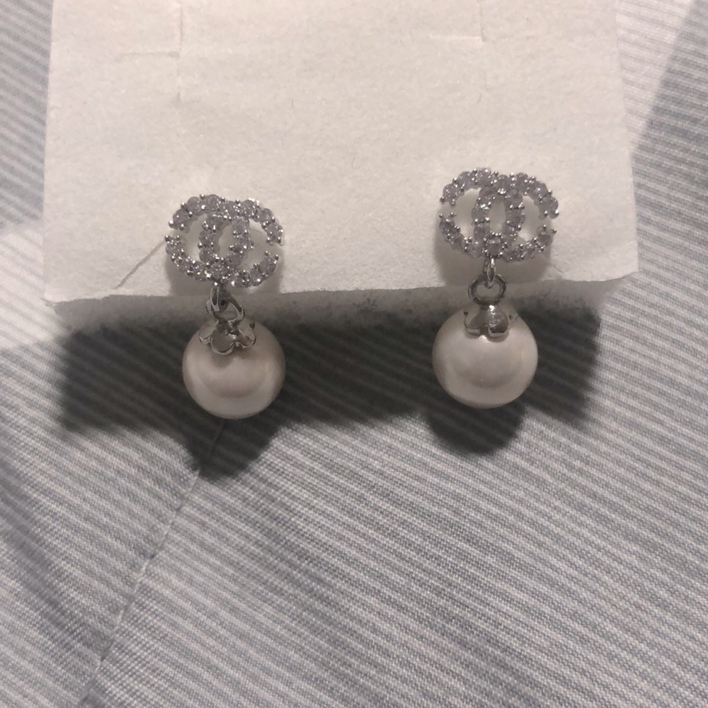 Fashion studded earrings with hanging pearls.